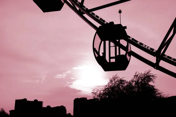 a fragment of the Ferris wheel against the background of an enchanting sunset. copy space to the left.