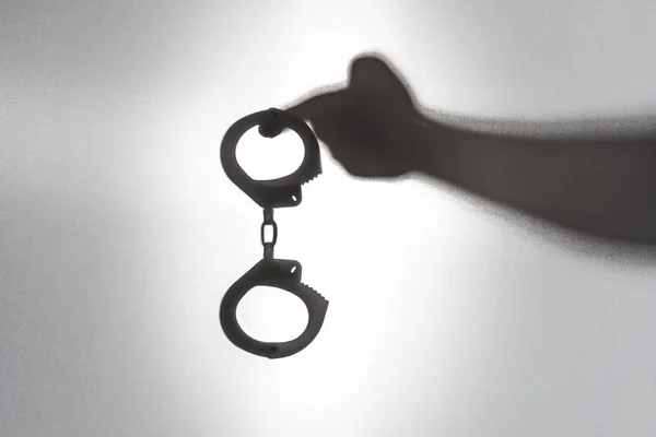 Kelepçelerin suçlular için hazır. Tutuklama kavramı. Şerif'in el silüeti tutun kelepçe