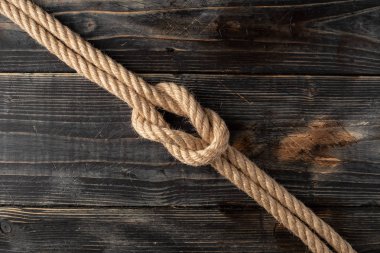 Square knot. Nautical rope knot on wooden desk