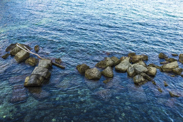 イタリア シチリア島のシラクサの背景としての遊歩道の横にある岩とクリスタル クリアな海 — ストック写真