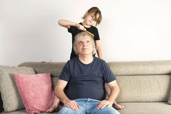 Bambina Pettinando Suo Padre Sul Divano Casa — Foto Stock