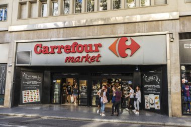 Barcelona, İspanya - 20 Eylül 2017: Genç turistler önünde Les Ramblas'a, Barcelona, Katalonya, İspanya'da bir Carrefour Pazar