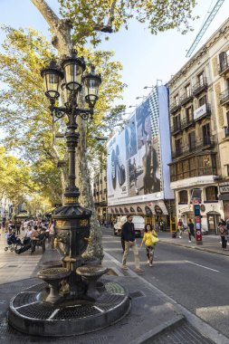 Barcelona, İspanya - 20 Eylül 2017: Yazı tipi de Canaletes, süslü Çeşme Les Ramblas'a, Barcelona, Katalonya, İspanya içinde dolaşan insanlarla bir lamba sonrası tarafından taç