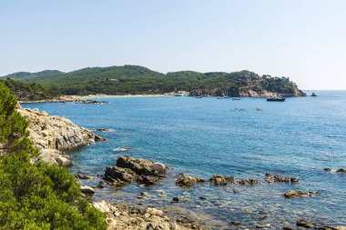 İnsanlar kayık yanındaki kayalıklardan Costa Brava, Girona, Katalonya, İspanya içinde kristal berraklığında su ile