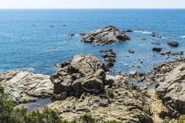 İnsanlar kayık yanındaki kayalıklardan Costa Brava, Girona, Katalonya, İspanya içinde kristal berraklığında su ile
