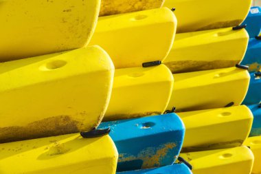 Sarı ve mavi kayaks veya arka plan olarak bir plajda plastikten tekneler yığını