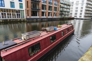 Kırmızı gemi güneş Regent's kanalı ile Londra, İngiltere, Birleşik Krallık'taki modern binalar Camden Market yakın gezinme paneli ile