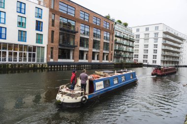 Londra, İngiltere - 31 Aralık 2017: gemi liderliğindeki bir adam Camden Market yakın yönetiminde Londra, İngiltere, Birleşik Krallık'taki modern binalar ile Regent's kanal için gezinme