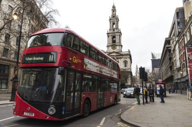 London, Büyük Britanya - 1 Ocak 2018: etrafında insanlar ve Londra, İngiltere için arka planda iki kilise ile dolaşan kırmızı katlı otobüs