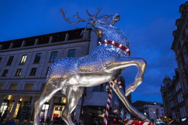 London, Büyük Britanya - 1 Ocak 2018: Covent Garden, mağazalar ve restoranlar, Noel motifleri ve Londra, İngiltere, Birleşik Krallık'taki etrafında insanlar süslenmiş bir geyik ile alışveriş merkezi