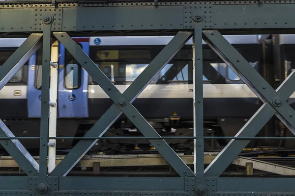 火车在一座金属桥上行驶 在泰晤士河上的铁路上有许多铁轨 — 图库照片