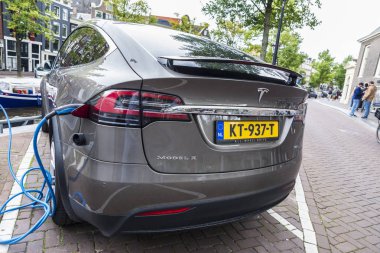 Amsterdam, Hollanda - 8 Eylül 2018: Elektrikli otomobil Tesla Model X bir güç istasyonu Amsterdam, Hollanda bir sokakta takılı 