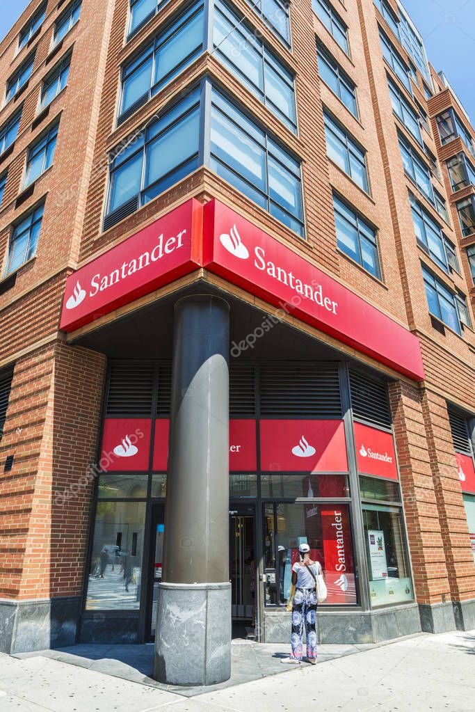 New York City, USA - July 26, 2018: Facade of a bank branch of Santander Bank on the street with people around in New York City, USA