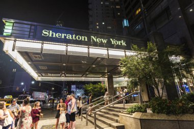 New York City, USA - July 30, 2018: Sheraton New York Times Square Hotel at night on Seventh Avenue (7th Avenue) next to Times Square with people around in Manhattan in New York City, USA clipart