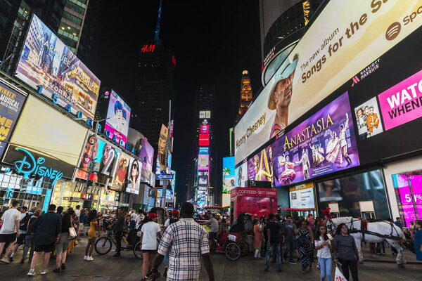 New York City, USA - July 30, 2018: Times Square at night with people around and large advertising screens in Manhattan in New York City, USA