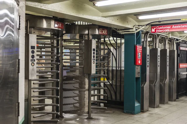 Automatic access control ticket barriers in subway station with signs of entry and exit in New York City, USA