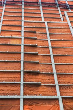 Turuncu bir güvenlik ağı Manhattan New York City, Amerika Birleşik Devletleri içinde modern bir gökdelen inşaat beton yapı kaplı