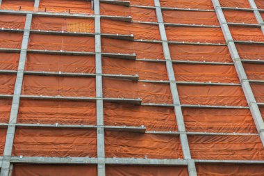 Turuncu bir güvenlik ağı Manhattan New York City, Amerika Birleşik Devletleri içinde modern bir gökdelen inşaat beton yapı kaplı