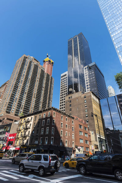 New York City, USA - July 28, 2018: 8th Avenue (Eight Avenue) with its modern skyscrapers with traffic and people around in Manhattan, New York City, USA