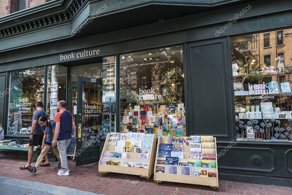 New York City, USA - July 29, 2018: Book Culture on Columbus store with a girl passing between two men in Columbus Avenue, Manhattan, New York City, USA