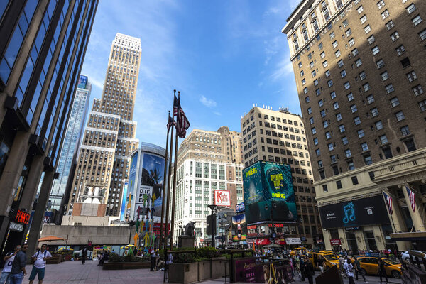 New York City, USA - July 31, 2018: Street with its skyscrapers, traffic, huge advertising screens and people around in Manhattan, New York City, USA