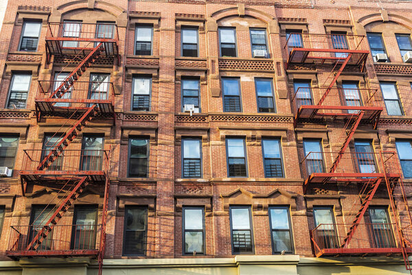 Old typical apartment buildings with its fire escape in the Harlem neighborhood in Manhattan, New York City, USA