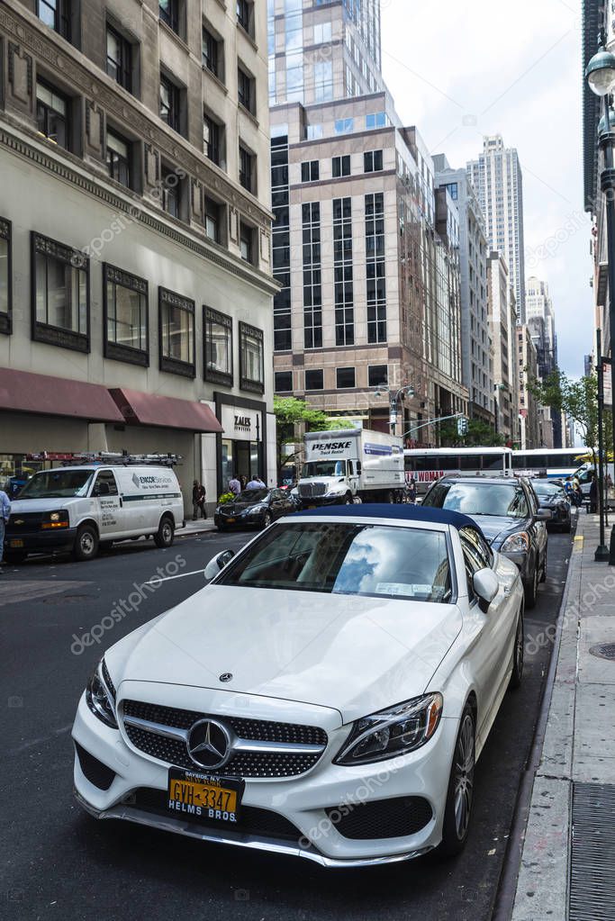 New York City, USA - August 2, 2018: Luxury white car of the Mercedes-Benz brand parked on a street with people around in Manhattan, New York City, USA