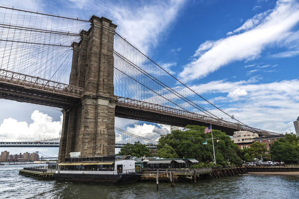 Column of the Brooklyn Bridge seen from East River in New York City, USA