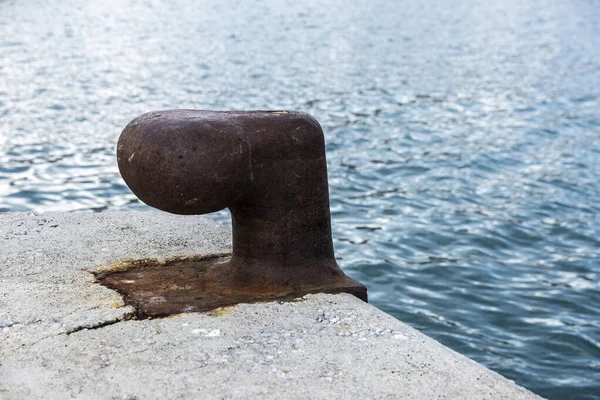 Antiguo amarradero de metal oxidado en un puerto como fondo —  Fotos de Stock