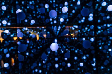 Birçok aydınlatılmış top ipliklerle asılmış ve birbirine bağlanmış soyut mavi arkaplan olarak sonsuz bir perspektif yaratıyor