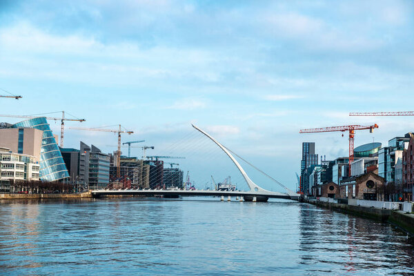 Dublin, Ireland - January 1, 2020: Samuel Beckett Bridge, designed by the architect Santiago Calatrava, and the Convention Centre Dublin, on the river Liffey in Grand Canal Dock, Dublin, Ireland