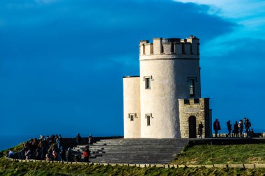 Moher, İrlanda - 3 Ocak 2020: O Briens Kulesi etrafında insanlar ile Moher Kayalıkları üzerinde, Burren Bölgesi 'nin güneybatı ucunda yer alan deniz kayalıkları