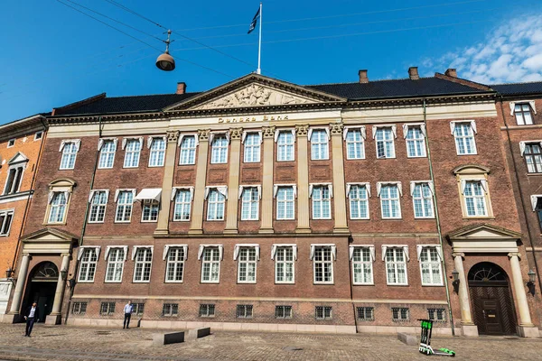 Kopenhag, Danimarka - 27 Ağustos 2019: Danimarka 'nın Kopenhag şehrinde limansız elektrikli scooter' ın park ettiği Danske Bank 'ın klasik bir binasının ön cephesi