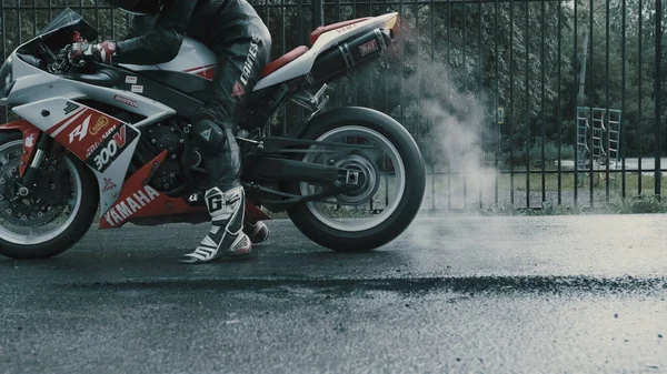 TOMSK, RUSSIA - 16 Mayıs 2020: Yamaha R1 etiketli ve tulumlu bir pilot çok duman çıkarıyor