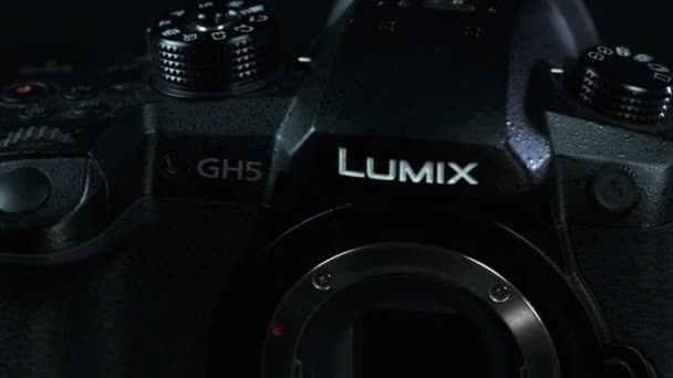 TOMSK, RUSIA - 28 de mayo de 2020: Panasonic Lumix DMC-GH5 cámara de pie sobre un tocadiscos negro sin lente, Micro Four Third System, fondo negro — Vídeos de Stock