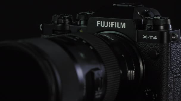 TOMSK, RUSKO - 28. května 2020: FUJIFILM X-T4 tělo s adaptérem Fringer ef-fx proII a sigmou 18-35 stojící na černém otočném stojanu, černé pozadí zblízka — Stock video
