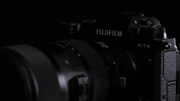TOMSK, RUSKO - 28. května 2020: FUJIFILM X-T4 tělo s adaptérem Fringer ef-fx proII a sigmou 18-35 stojící na černém otočném stojanu, černé pozadí — Stock video