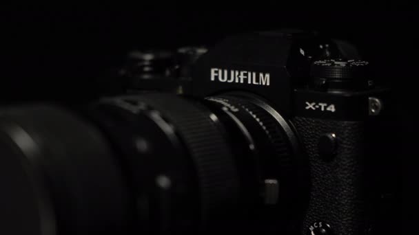 TOMSK, RUSIA - 28 de mayo de 2020: FUJIFILM X-T4 body with Fringer ef-fx proII adapter and sigma 18-35 standing on a black rotate stand, black background — Vídeo de stock