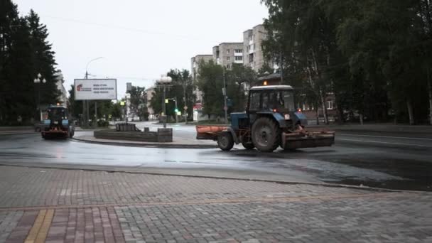 TOMSK, RUSKO - 2. června 2020: Traktory projíždějí ulicí a čistí asfalt — Stock video