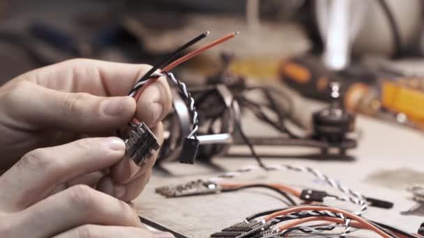 El hombre construye un helicóptero FPV en un taller. — Vídeo de stock