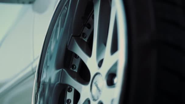 Widok z boku biały samochód sportowy i stylowe koło — Wideo stockowe