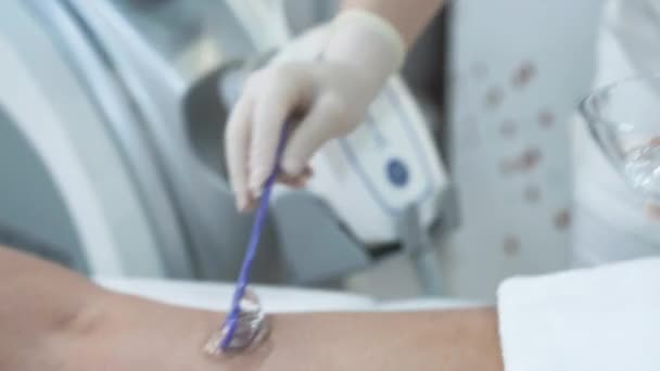 O médico cosmetologista aplica um gel transparente às pernas dos pacientes — Vídeo de Stock