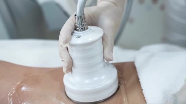Kosmetikerin trägt transparentes Gel auf die Beine des Patienten auf — Stockvideo