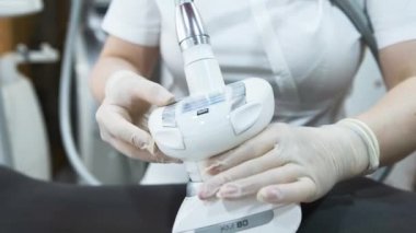 Doktor kozmetik uzmanı hasta bir kıza LPG masajı uygular.