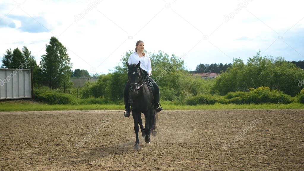 Girl in a white shirt and black pants rides a horse