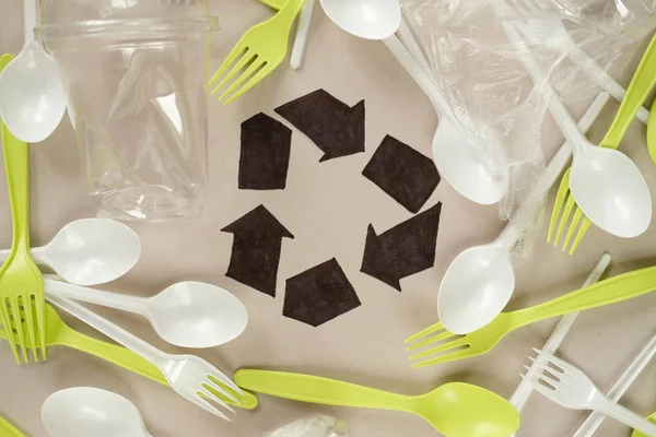 Plastik beyaz kaşıklar ve yeşil çatallar. gri arka plan. Ekoloji kavramı. kağıt alternatif olarak