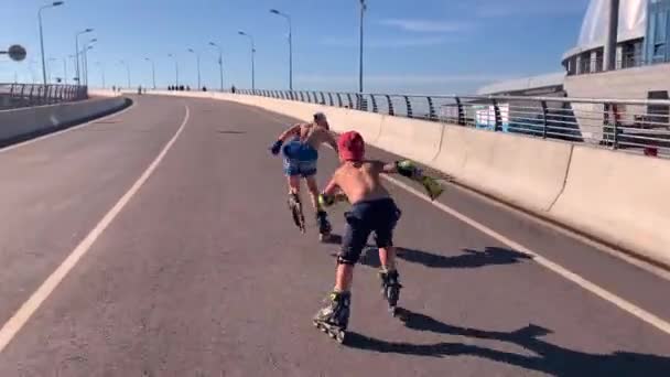 俄罗斯圣彼得堡 2019年9月1日 两个骑着溜冰鞋的男孩在阳光明媚的夏日骑上游艇桥 — 图库视频影像