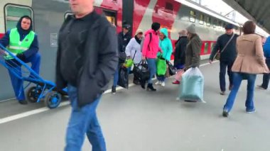 St. Petersburg, Rusya - 08 Ekim 2019: İnsanlar tren Moskova tren istasyonuna vardıktan sonra bavullarıyla tren istasyonuna gidiyorlar. Bagaj vagonlu yükleyici iş bekliyor..