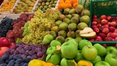 Marketteki tezgahın üzerindeki tahta sandıklarda çeşitli lezzetli doğal meyveler. Üzüm, limon, elma, armut, mandalina, hurma, erik, nar, karpuz, portakal..
