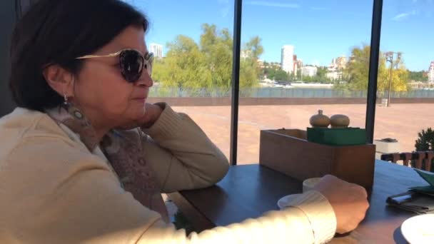 Une jeune fille et une femme âgée s'assoient dans un café, boivent du café et mangent des bonbons .